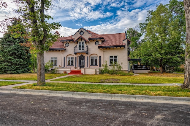 mediterranean / spanish-style home featuring a front yard