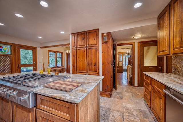 kitchen featuring appliances with stainless steel finishes, a center island, and light stone counters