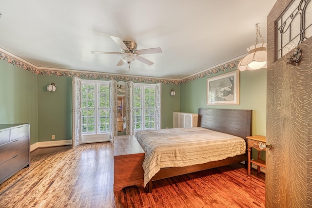 bedroom with hardwood / wood-style floors, ceiling fan, and crown molding