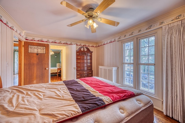 bedroom featuring ceiling fan, wood-type flooring, and ornamental molding