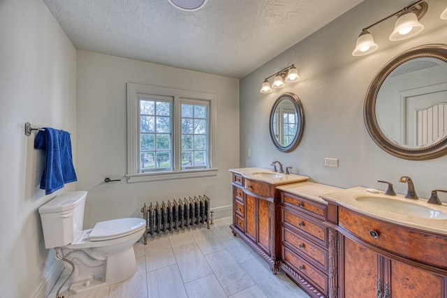 bathroom featuring vanity, toilet, a textured ceiling, and radiator
