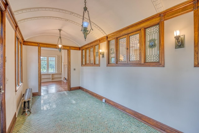 corridor with brick ceiling, radiator, and vaulted ceiling
