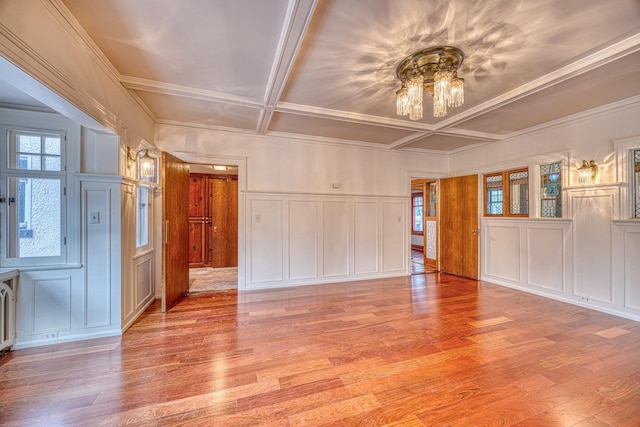 unfurnished room with light hardwood / wood-style floors and coffered ceiling