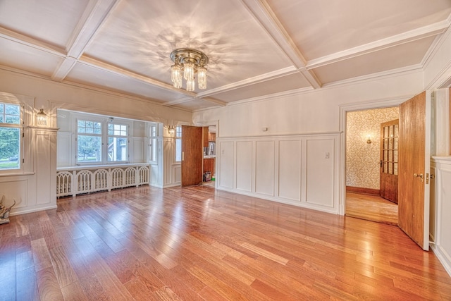 unfurnished living room featuring light hardwood / wood-style flooring, radiator, and coffered ceiling