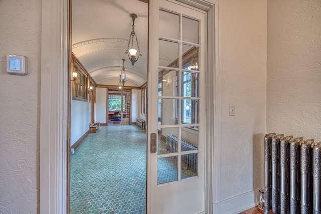 hallway with radiator and vaulted ceiling