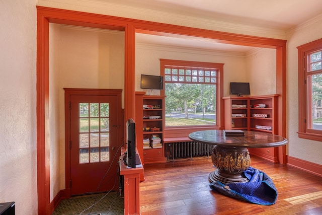 office space with hardwood / wood-style floors, crown molding, and radiator