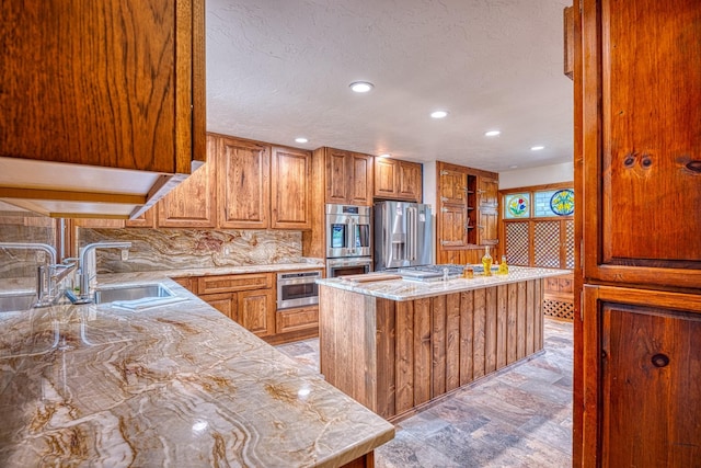 kitchen with tasteful backsplash, light stone countertops, sink, and stainless steel appliances