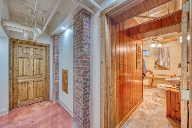 hallway with wooden walls and sink