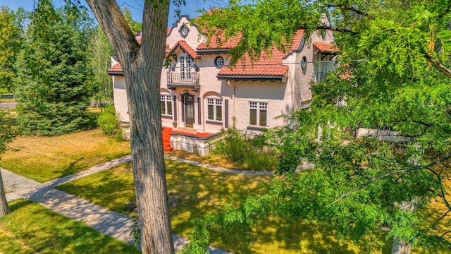 view of front facade featuring a front yard and a balcony