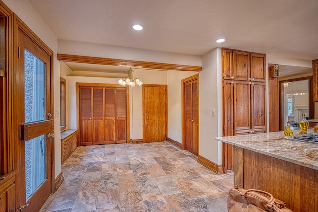 kitchen featuring light stone counters, hanging light fixtures, and a notable chandelier