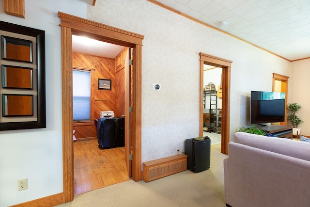 living room featuring light colored carpet, crown molding, and wooden walls