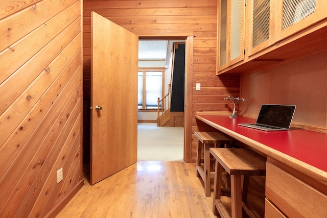 interior space with light hardwood / wood-style flooring and wooden walls