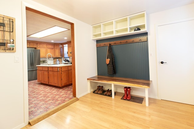 mudroom with sink and light hardwood / wood-style flooring