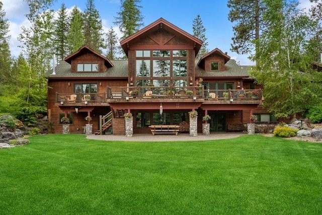 rear view of house featuring a yard, a patio area, and a wooden deck