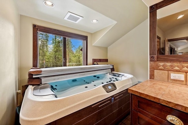 bathroom with backsplash and vaulted ceiling