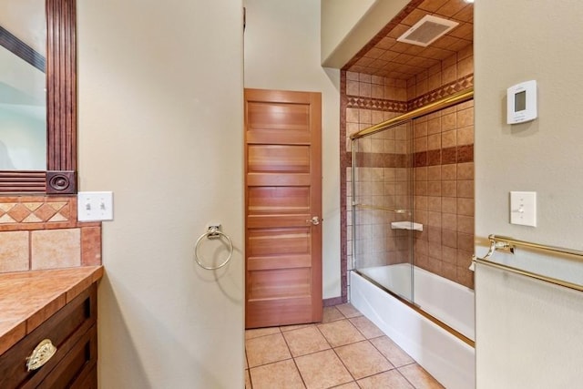 bathroom featuring tile patterned floors, vanity, and bath / shower combo with glass door