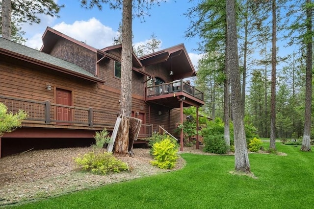 rear view of property featuring a yard and a balcony