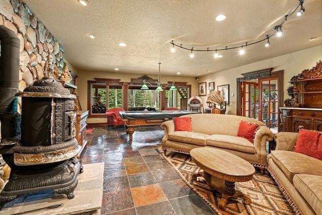 living room featuring a wood stove, french doors, a textured ceiling, and billiards