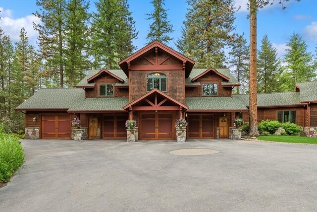 940 Mccaffery Rd, Bigfork, MT 59911 - view of front facade featuring a garage, stone siding, driveway, and a shingled roof