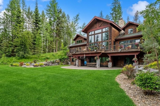 back of property with a yard, a patio, and a wooden deck