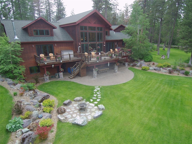 940 Mccaffery Rd, Bigfork, MT 59911 - rear view of house with a patio area, a deck, a yard, stairs, and a shingled roof