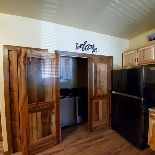 940 Mccaffery Rd, Bigfork, MT 59911 - kitchen with freestanding refrigerator, washer and clothes dryer, dark wood-style floors, and light brown cabinets