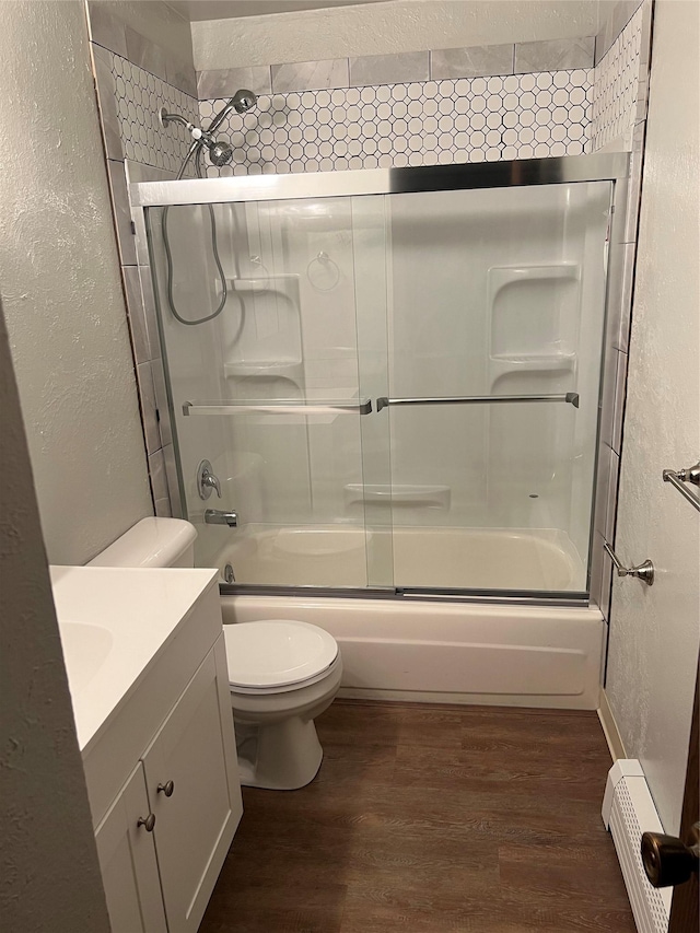 full bathroom with vanity, baseboard heating, wood-type flooring, enclosed tub / shower combo, and toilet