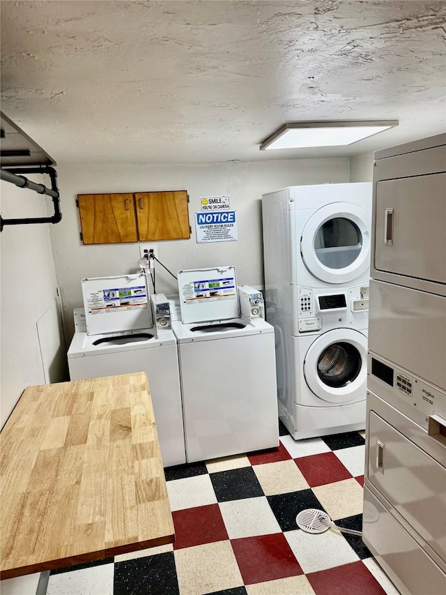 laundry room with a textured ceiling, separate washer and dryer, and stacked washer and clothes dryer