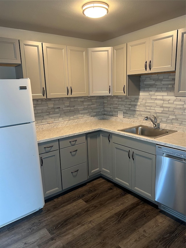 kitchen featuring sink, white refrigerator, dishwasher, dark hardwood / wood-style floors, and white cabinetry