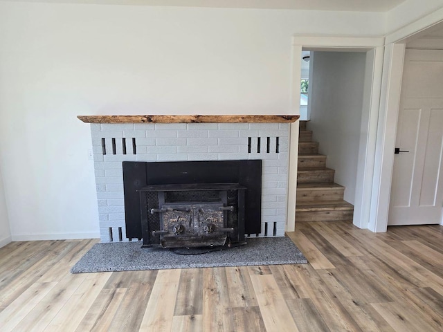 interior details with a brick fireplace and hardwood / wood-style floors