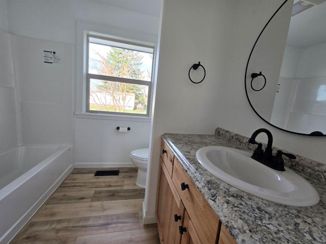 full bathroom featuring toilet, wood-type flooring, vanity, and bathtub / shower combination