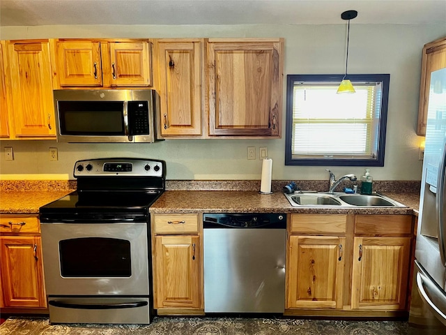 kitchen with stainless steel appliances, hanging light fixtures, and sink