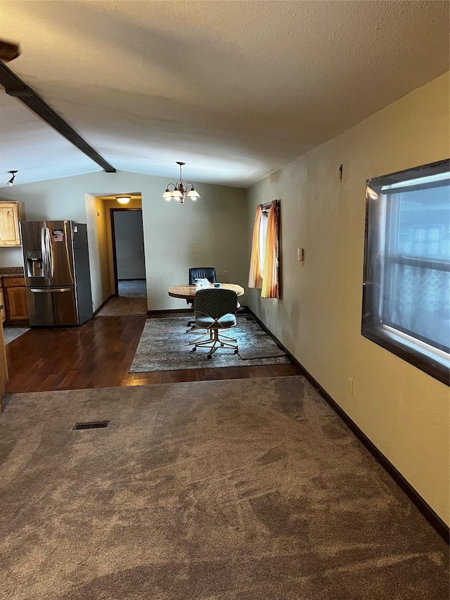 interior space featuring dark colored carpet, vaulted ceiling with beams, a textured ceiling, and a chandelier