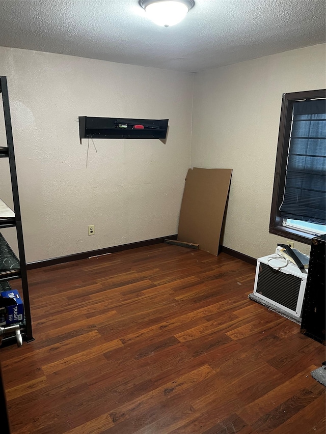 spare room featuring dark hardwood / wood-style flooring and a textured ceiling