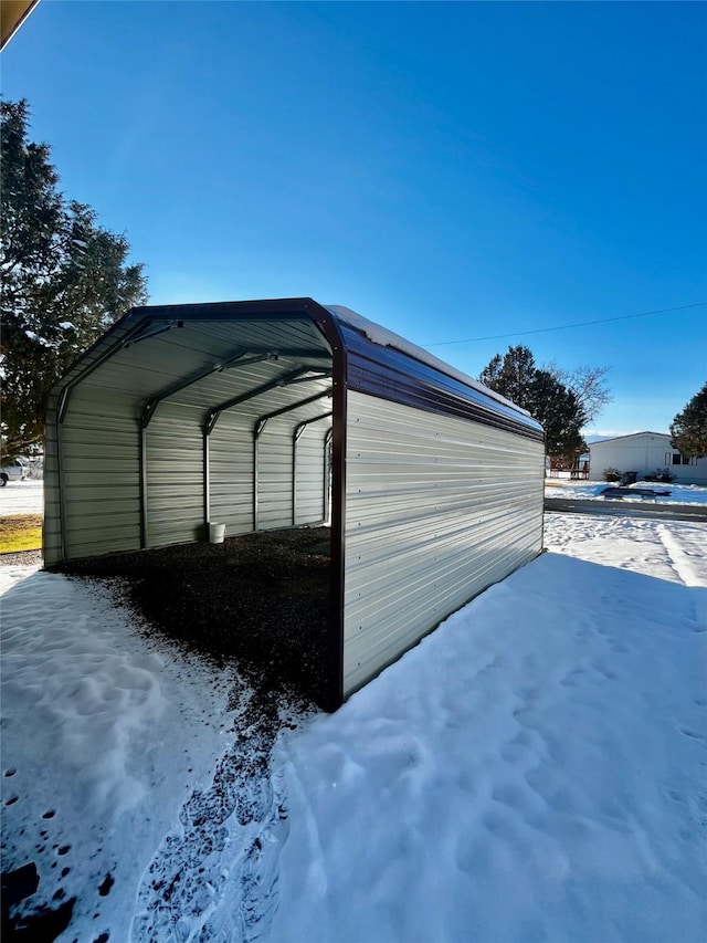 snow covered structure featuring a carport