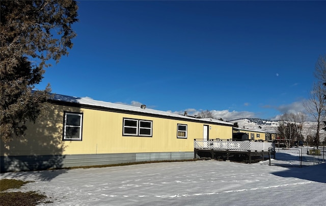 view of snowy exterior featuring a wooden deck