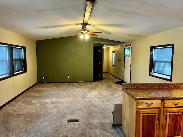 interior space featuring ceiling fan, light colored carpet, and lofted ceiling