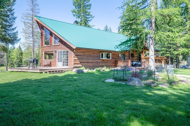 rear view of house featuring a lawn and a wooden deck