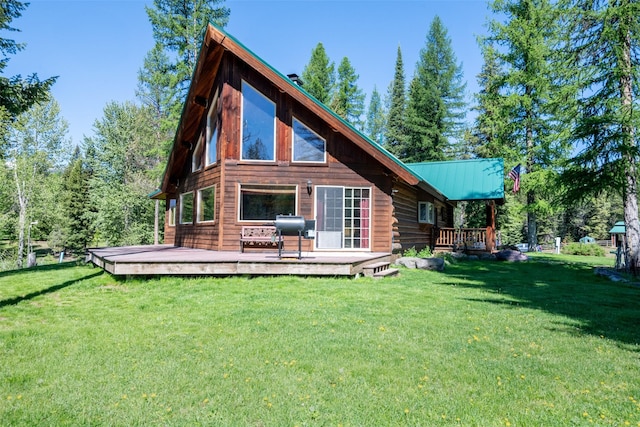 back of house featuring a wooden deck and a lawn