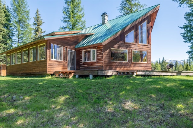 rear view of house with a yard and a sunroom