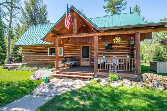 back of house featuring covered porch and a lawn