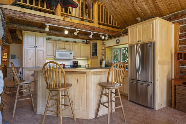 kitchen featuring wood ceiling, stainless steel fridge, light brown cabinetry, and dark tile patterned flooring