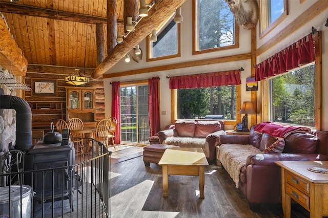 interior space featuring beam ceiling, wooden ceiling, and a wood stove