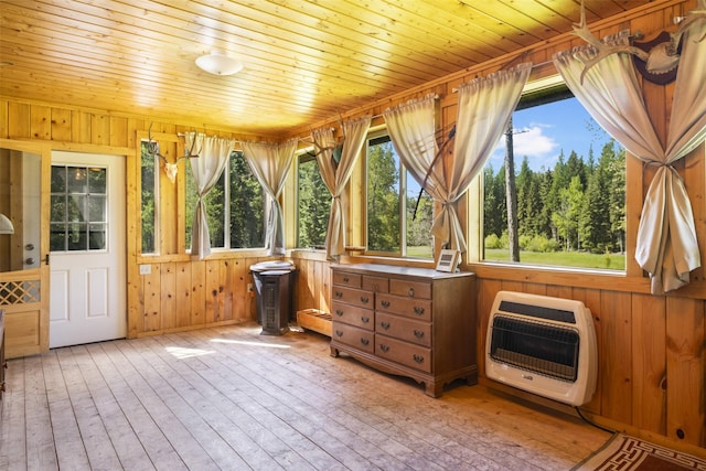 unfurnished sunroom featuring a wealth of natural light, wood ceiling, and heating unit