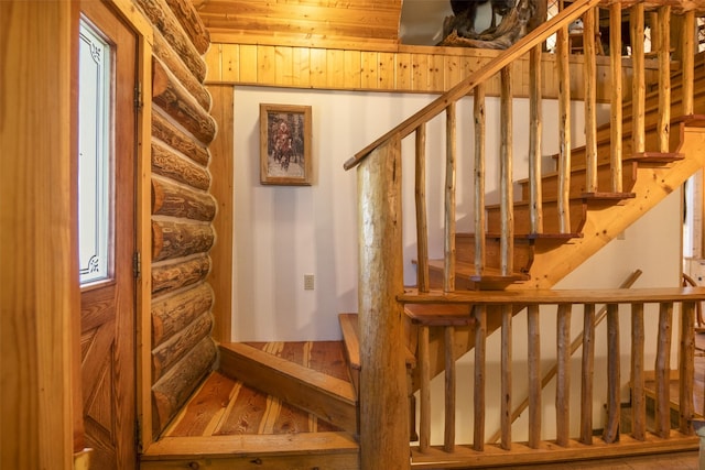 staircase featuring hardwood / wood-style floors and log walls