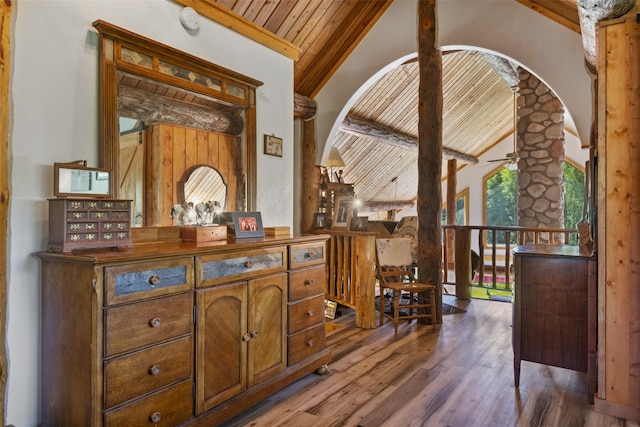 interior space with dark wood-type flooring, ceiling fan, wood ceiling, and vaulted ceiling with beams