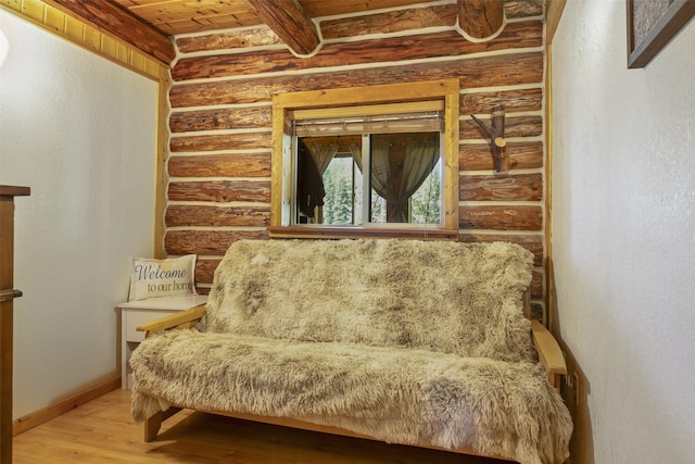 sitting room with hardwood / wood-style flooring, wooden ceiling, and log walls