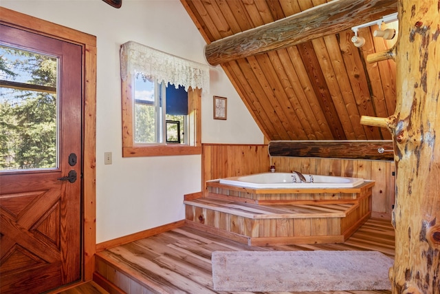 interior space with vaulted ceiling with beams, wood ceiling, and light hardwood / wood-style floors