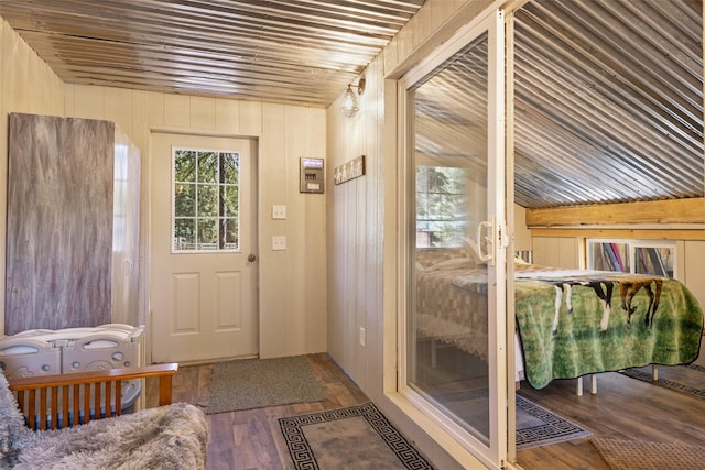 doorway featuring wooden walls, hardwood / wood-style floors, and wood ceiling