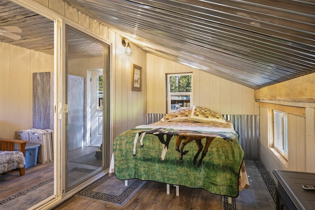 bedroom featuring dark wood-type flooring, vaulted ceiling, and wood walls